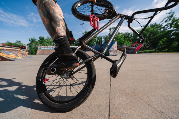 Cropped picture of an urban tattooed man doing freestyle tricks on